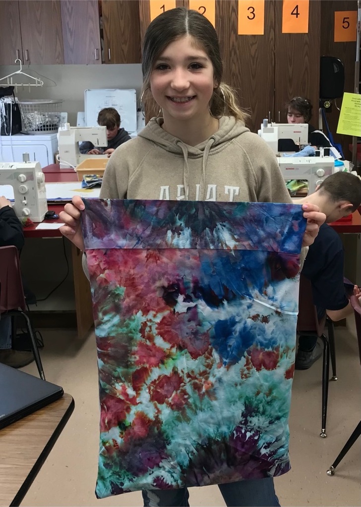 student holding dyed pillowcase
