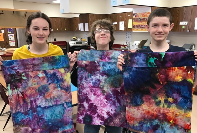 students holding dyed pillowcases